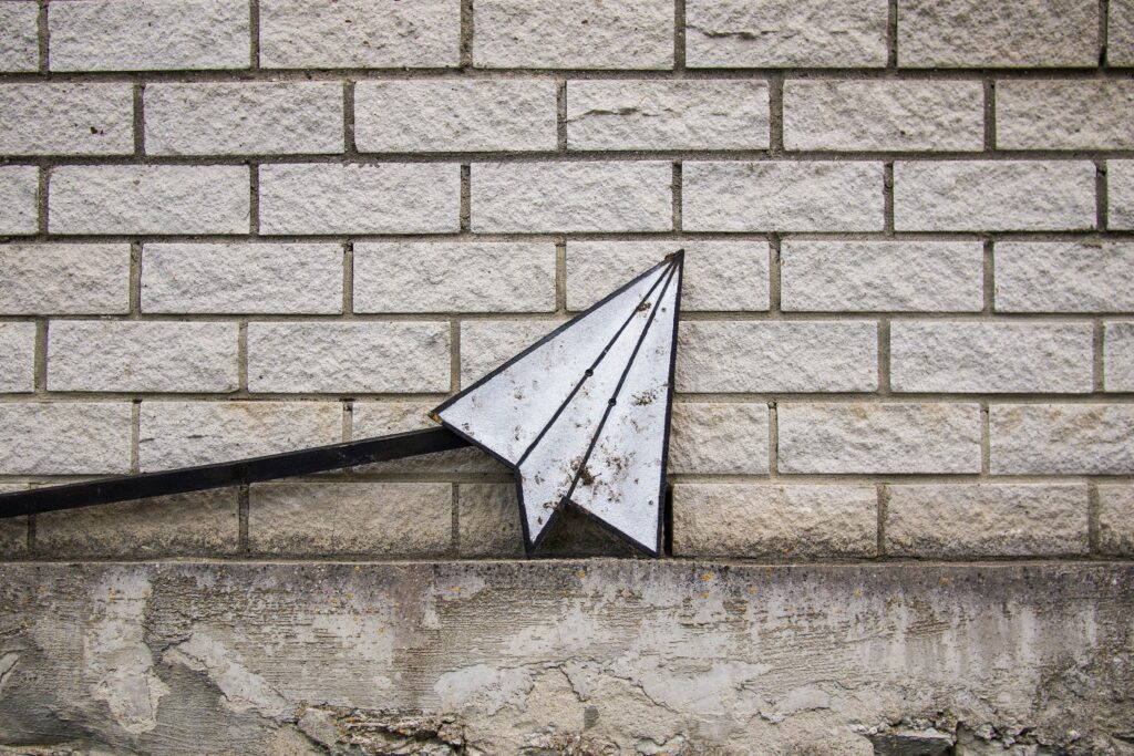 Signage in Tallinn, Estonia. A paper plane on a brick wall.